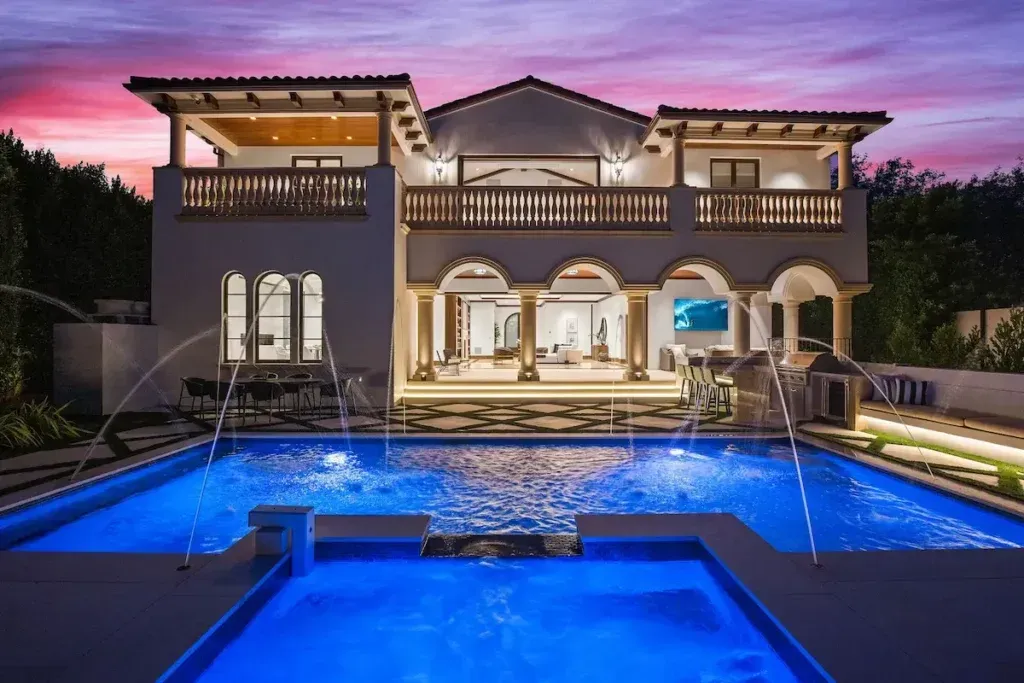 Alpine Mansion photographed at night with pool area